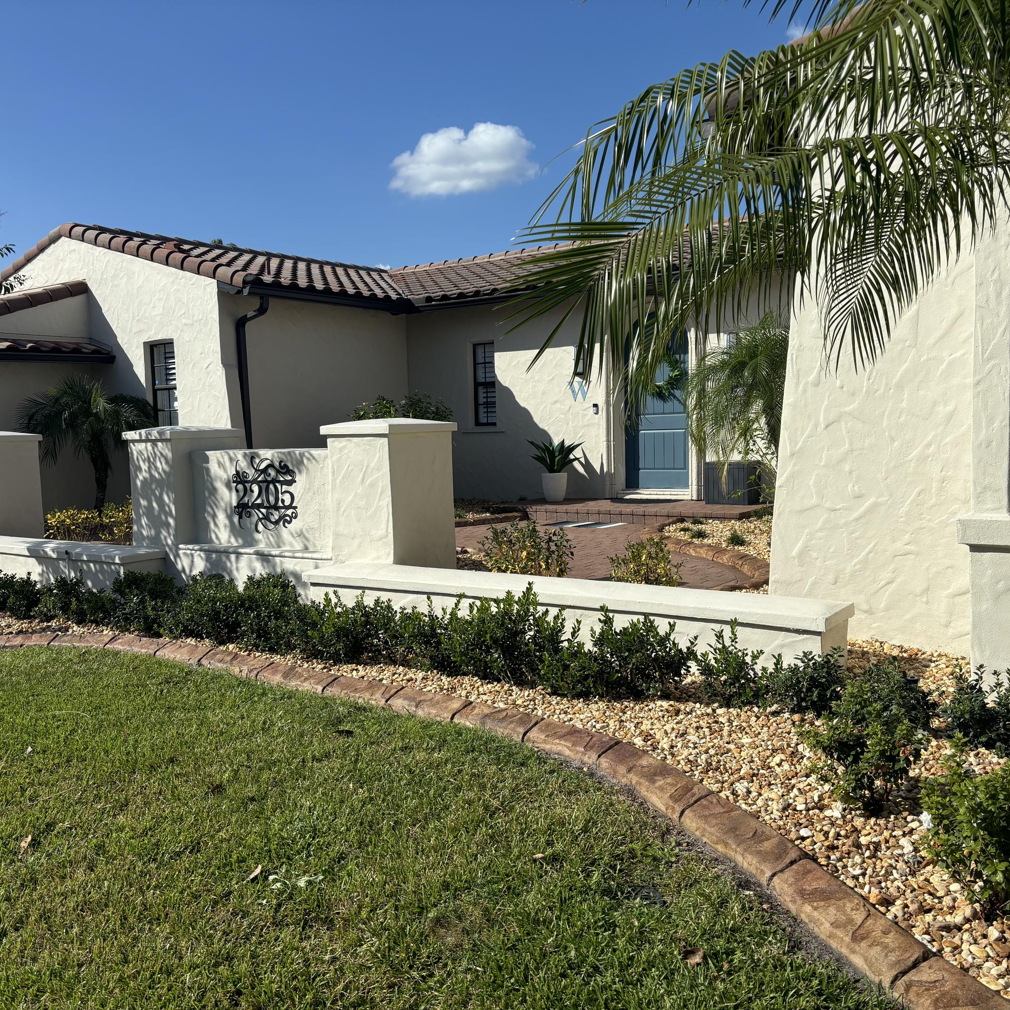 Exterior of home featuring a custom landscape curb around their hardscaped flower beds.
